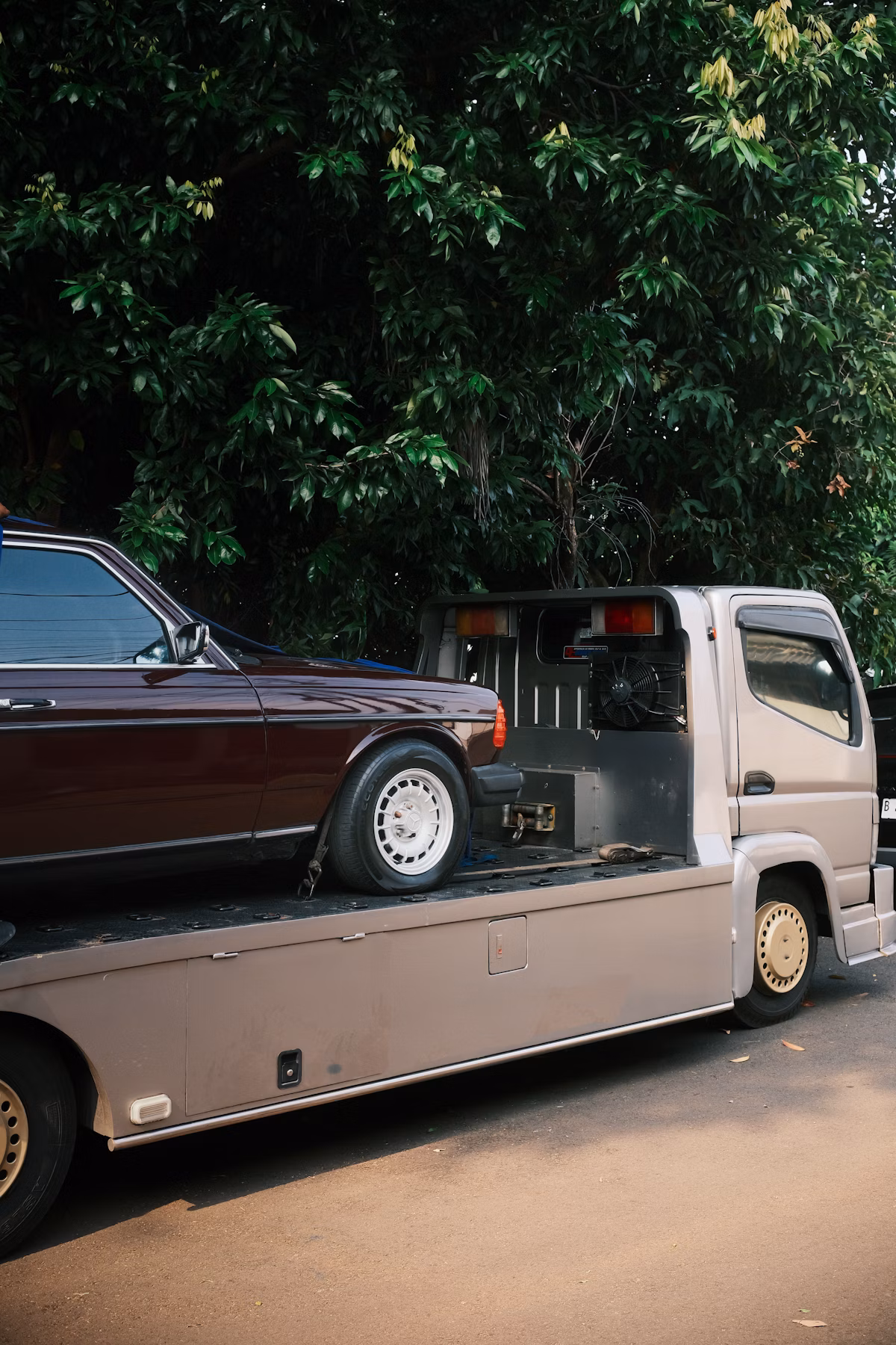 Car being loaded onto flatbed for transport after online purchase